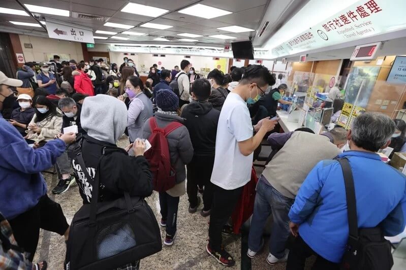 外交部領務局辦理護照的擁擠人潮，顯示眾多民眾在等候區和櫃檯前等待辦理護照。